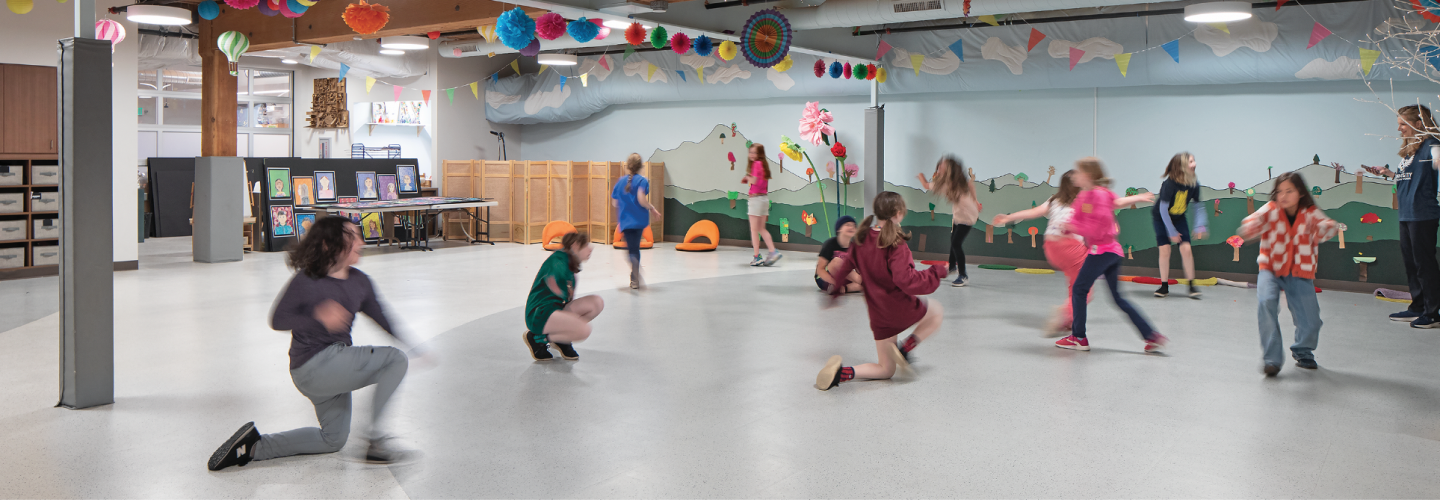 Children and instructors moving through a colorful learning environment with Zandur flooring